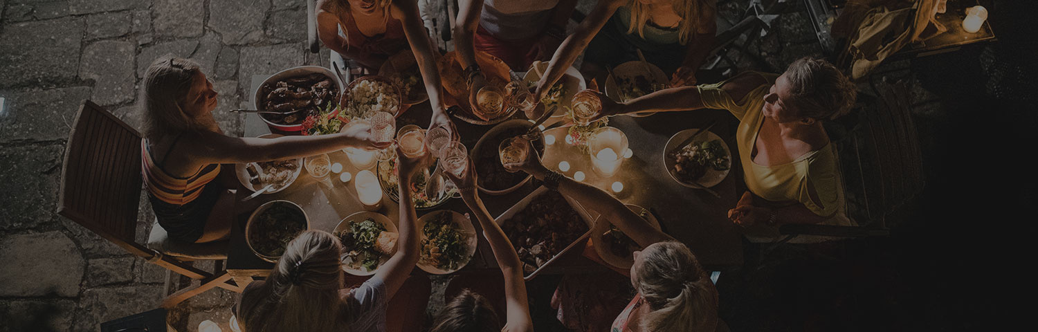 group of people toasting their drinks over dinner