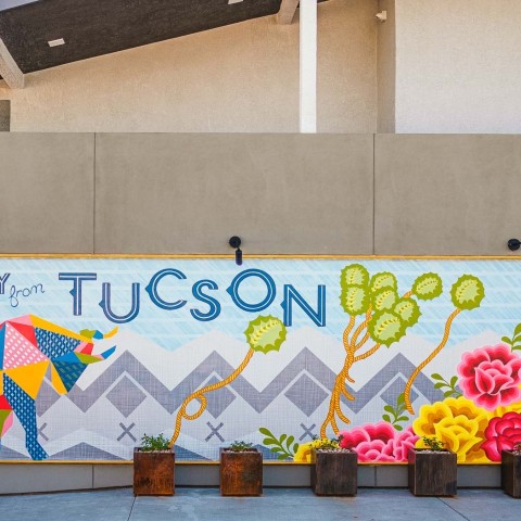 a wall with flowers and a sign