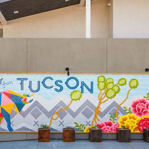 a wall with flowers and a sign