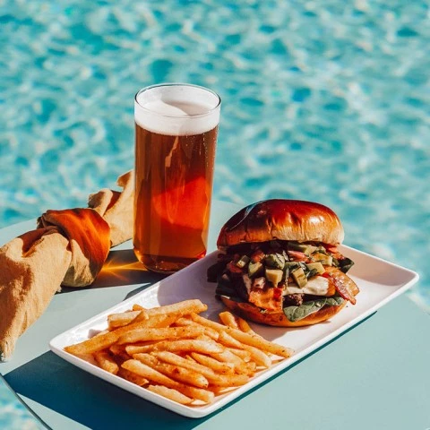 a plate of food and a glass of beer next to a drink