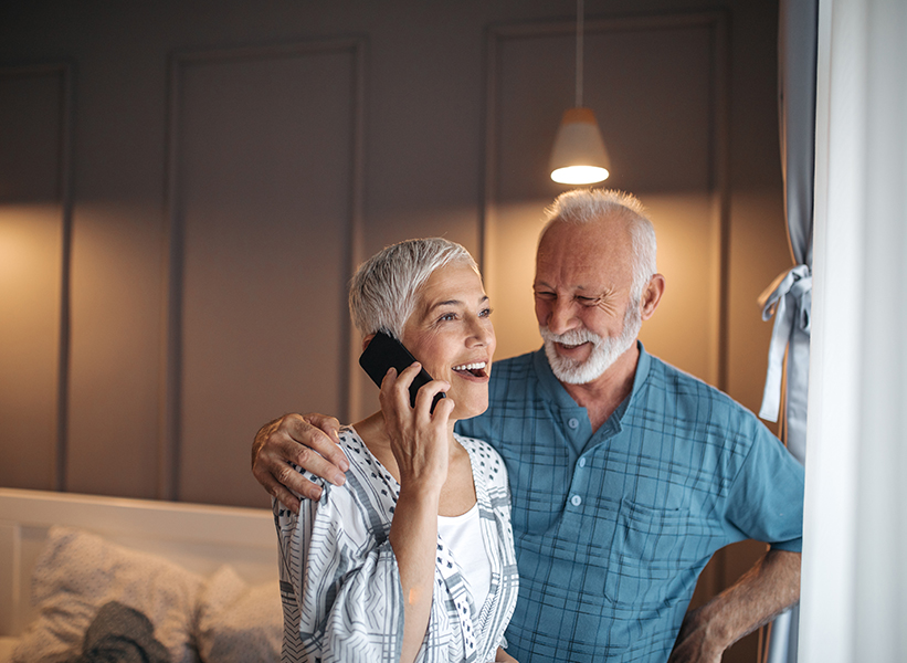 a man and woman smiling while talking on a phone