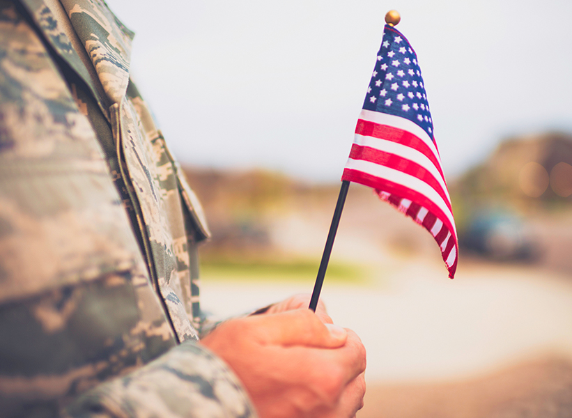 a person in military uniform holding a small flag