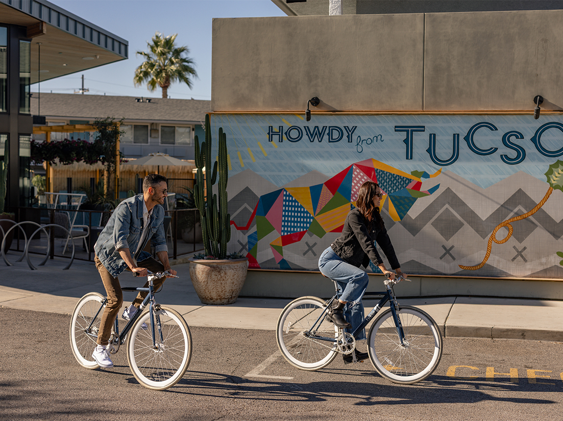 a man and woman riding bicycles on a street