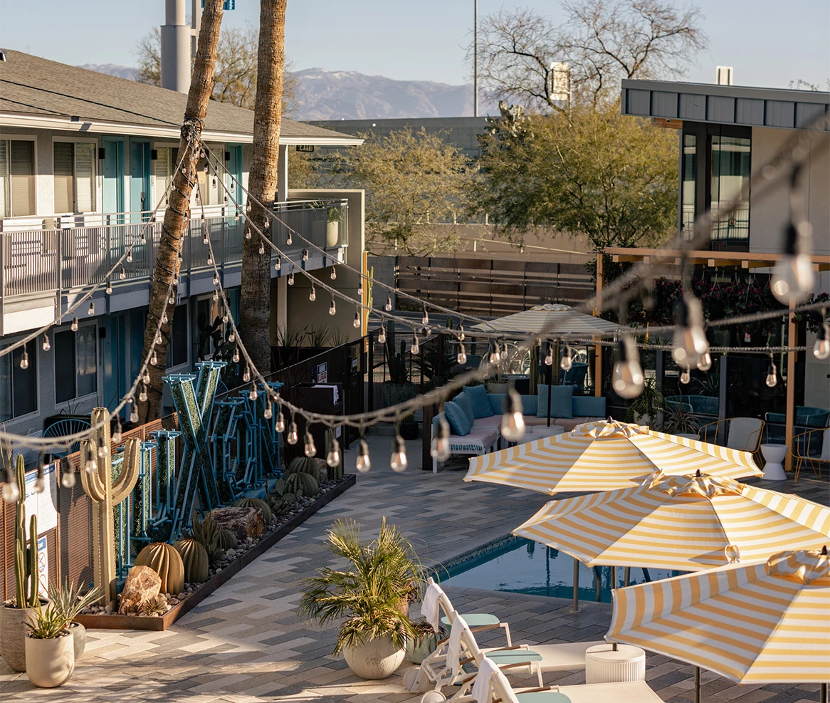 a pool and patio with umbrellas and chairs