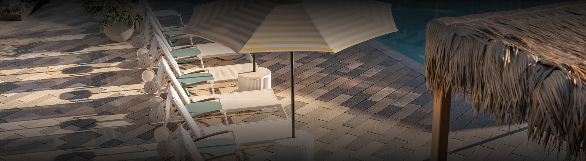 a umbrella and chairs on a brick surface