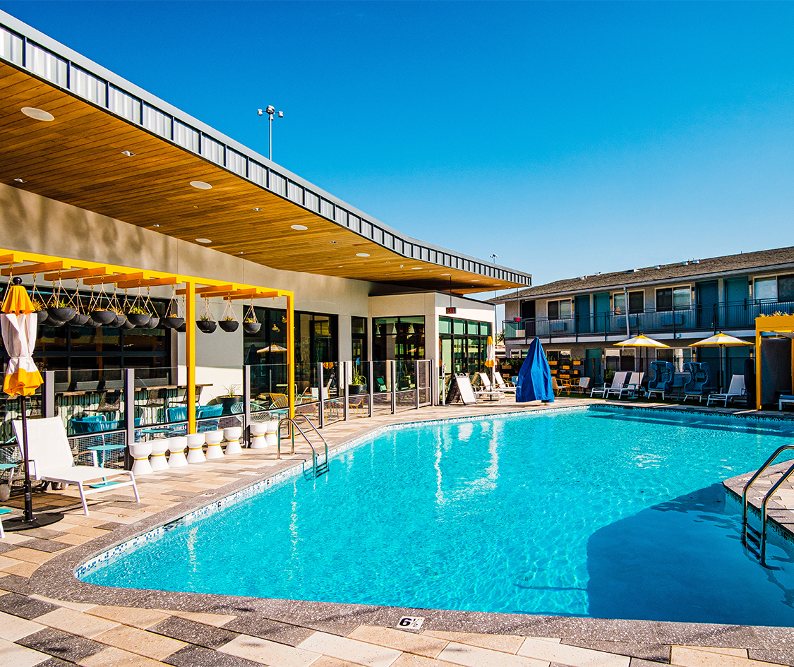a swimming pool with chairs and umbrellas