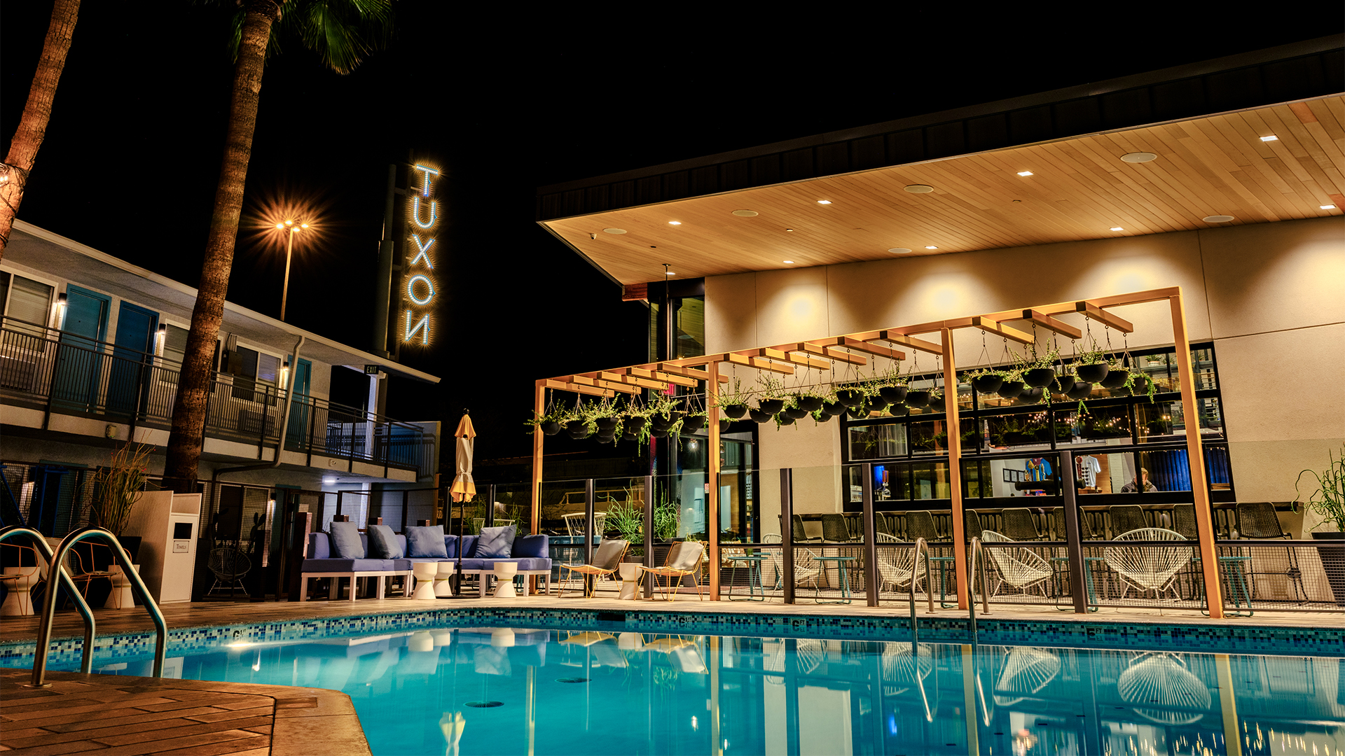 a pool with chairs and a building at night