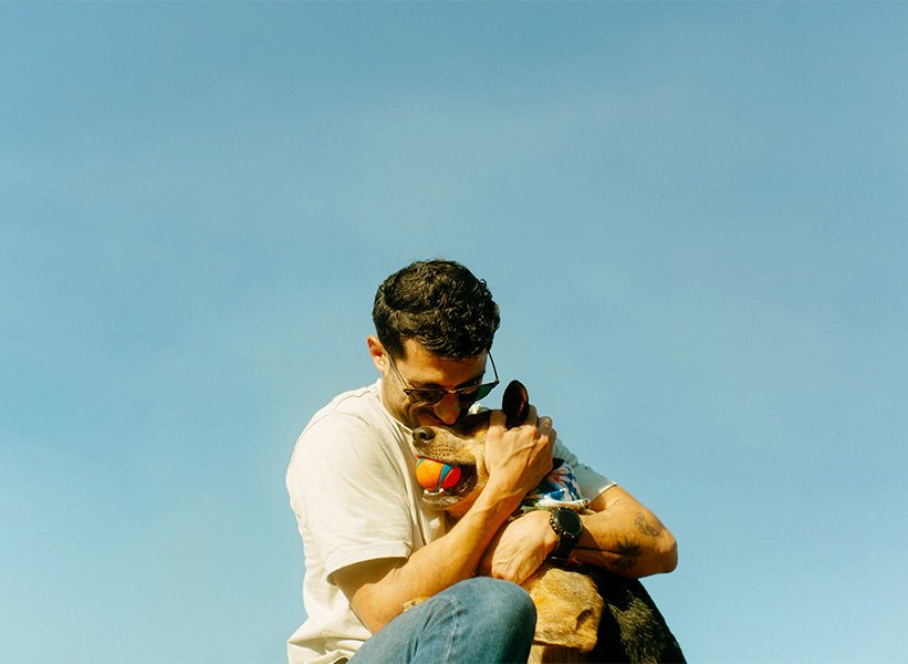 a man holding a dog with a ball