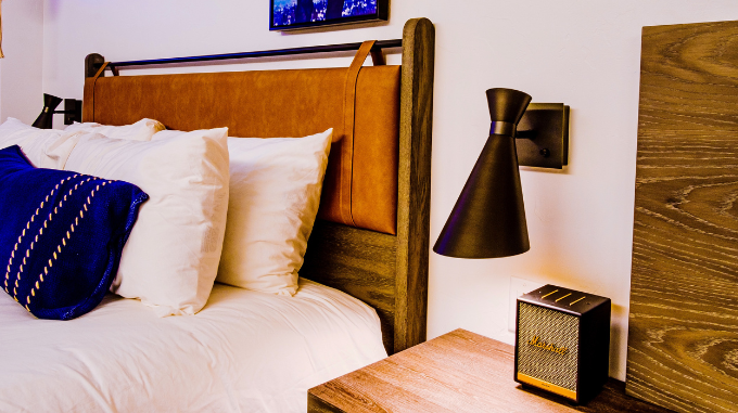 a bed with pillows and a lamp next to a table