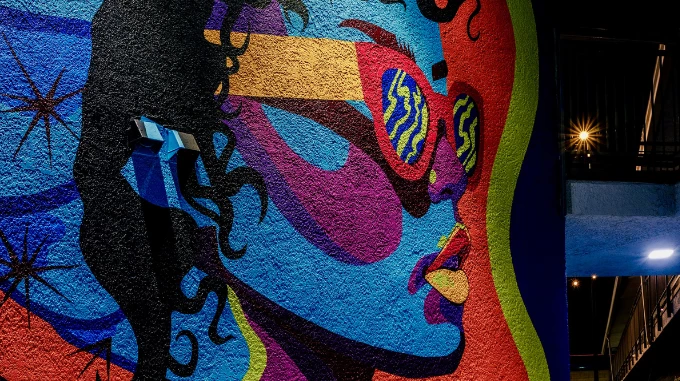 a mural of a woman with sunglasses on a wall