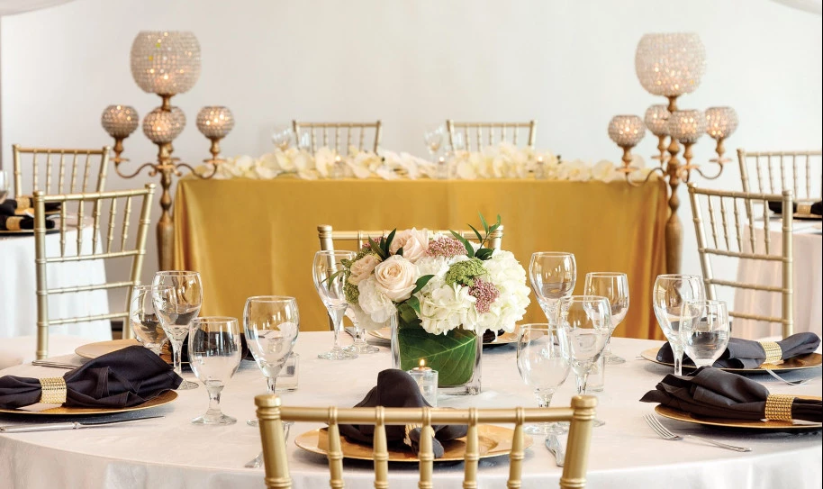 Tables set with white tablecloths and floral arrangements for an elegant event