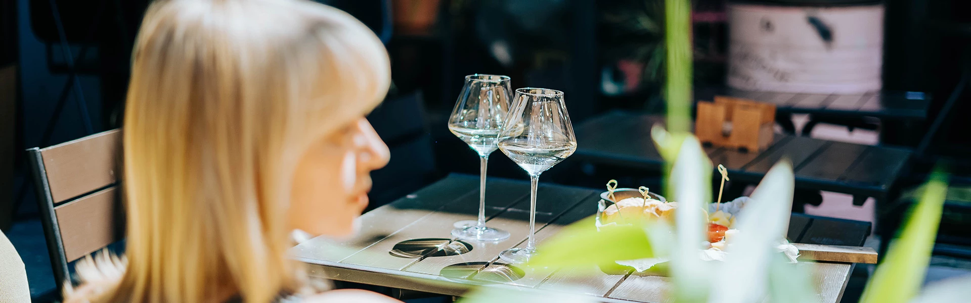 a woman sitting at a table with wine glasses and candles