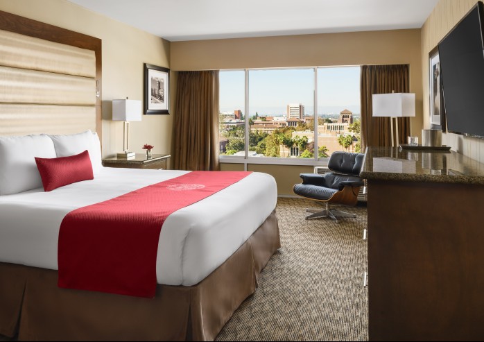 a hotel room with a large bed and a chair