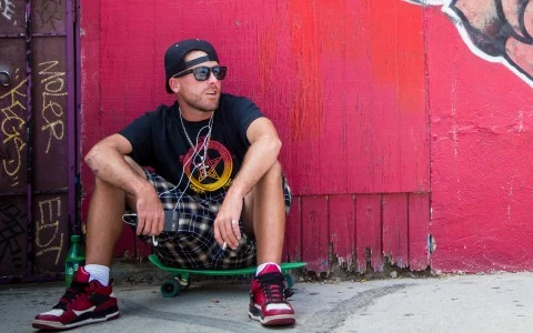 a man sitting on his skateboard outside 
