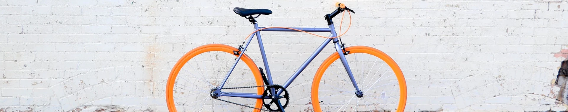 brightly colored bicycle against plain white brick wall 