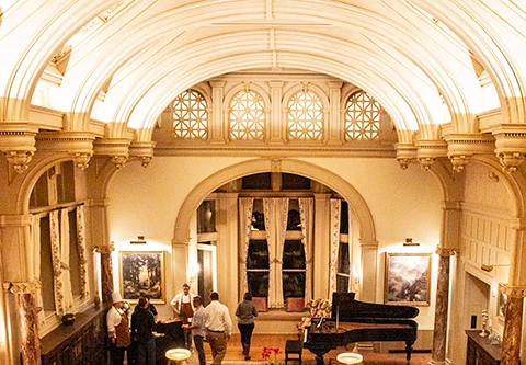 a group of people in a room with a piano