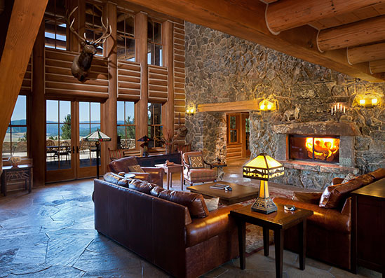 a living room with a stone fireplace and leather couches