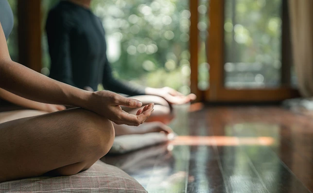 a person sitting on the floor with their hands in the air