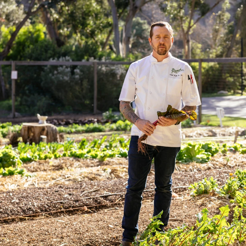 a man in a white shirt holding a plant