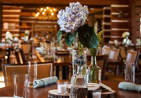 a table set with a vase of flowers and candles