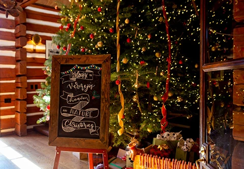 a christmas tree with lights and a chalkboard