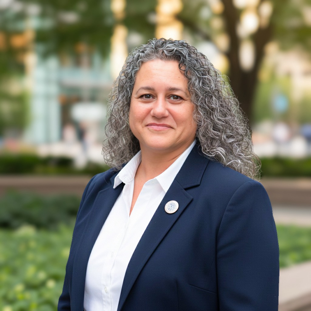 a woman with long curly hair wearing a suit