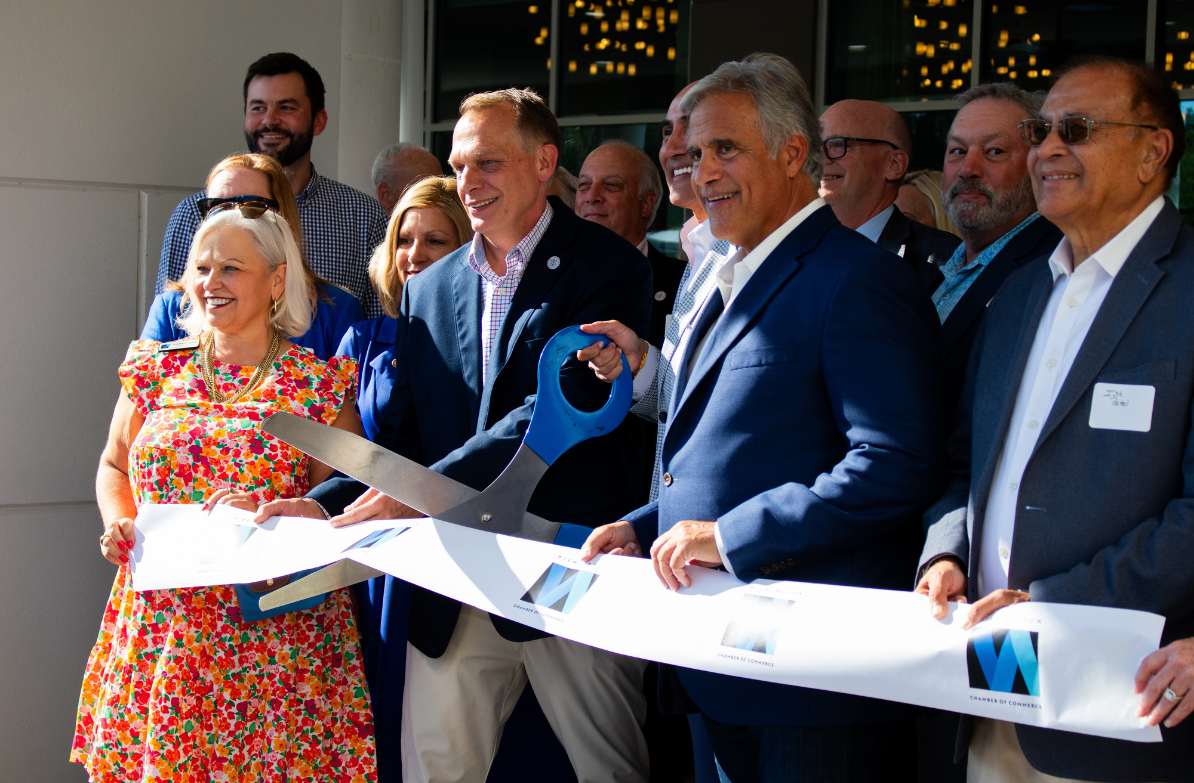 a group of people cutting a ribbon