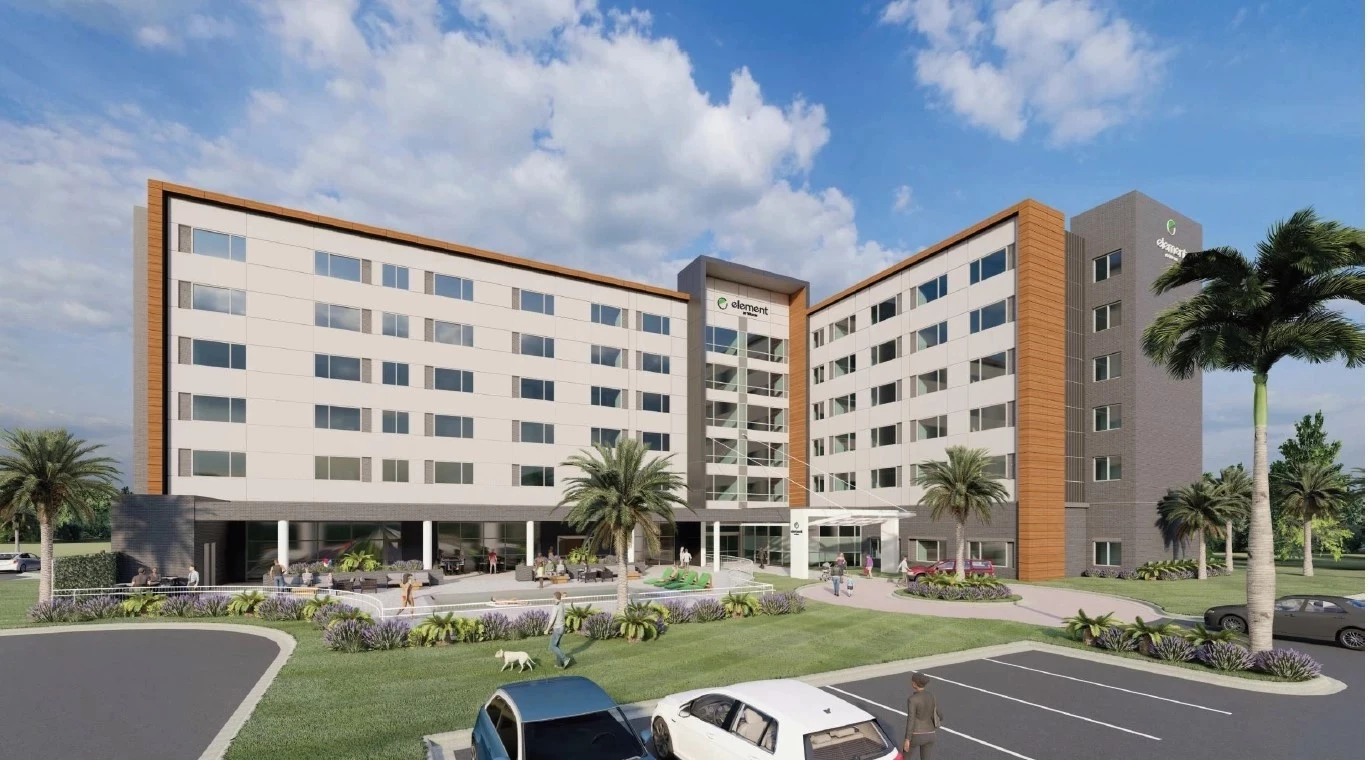 a building with palm trees and cars