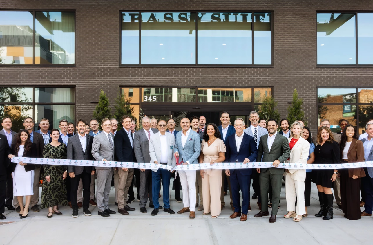 a group of people standing in front of a ribbon