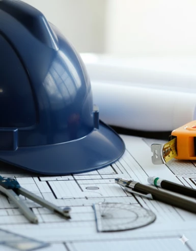 a blue helmet and tools on a blueprint