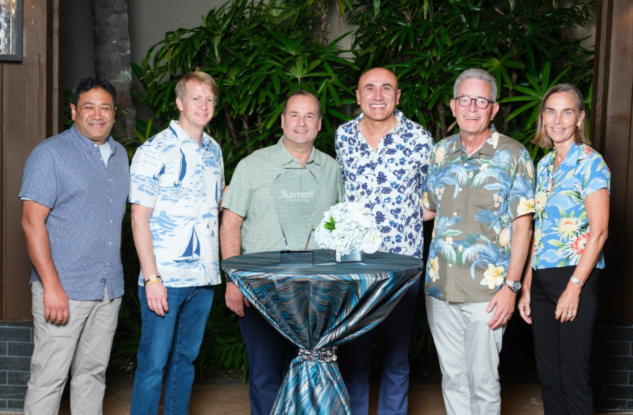 a group of men standing next to a table