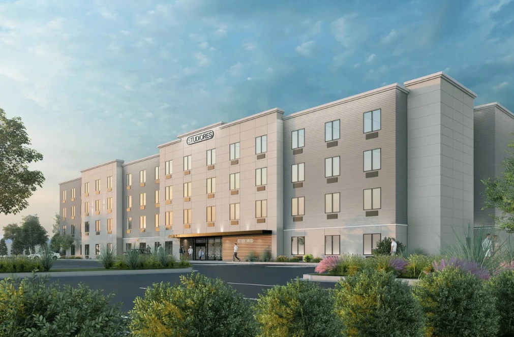 a building with a parking lot and trees