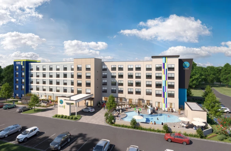 a building with a pool and cars parked in front of it