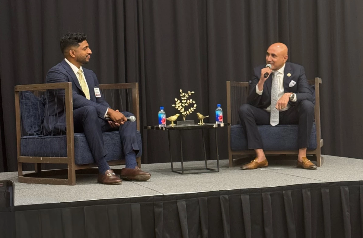 two men sitting in chairs on a stage