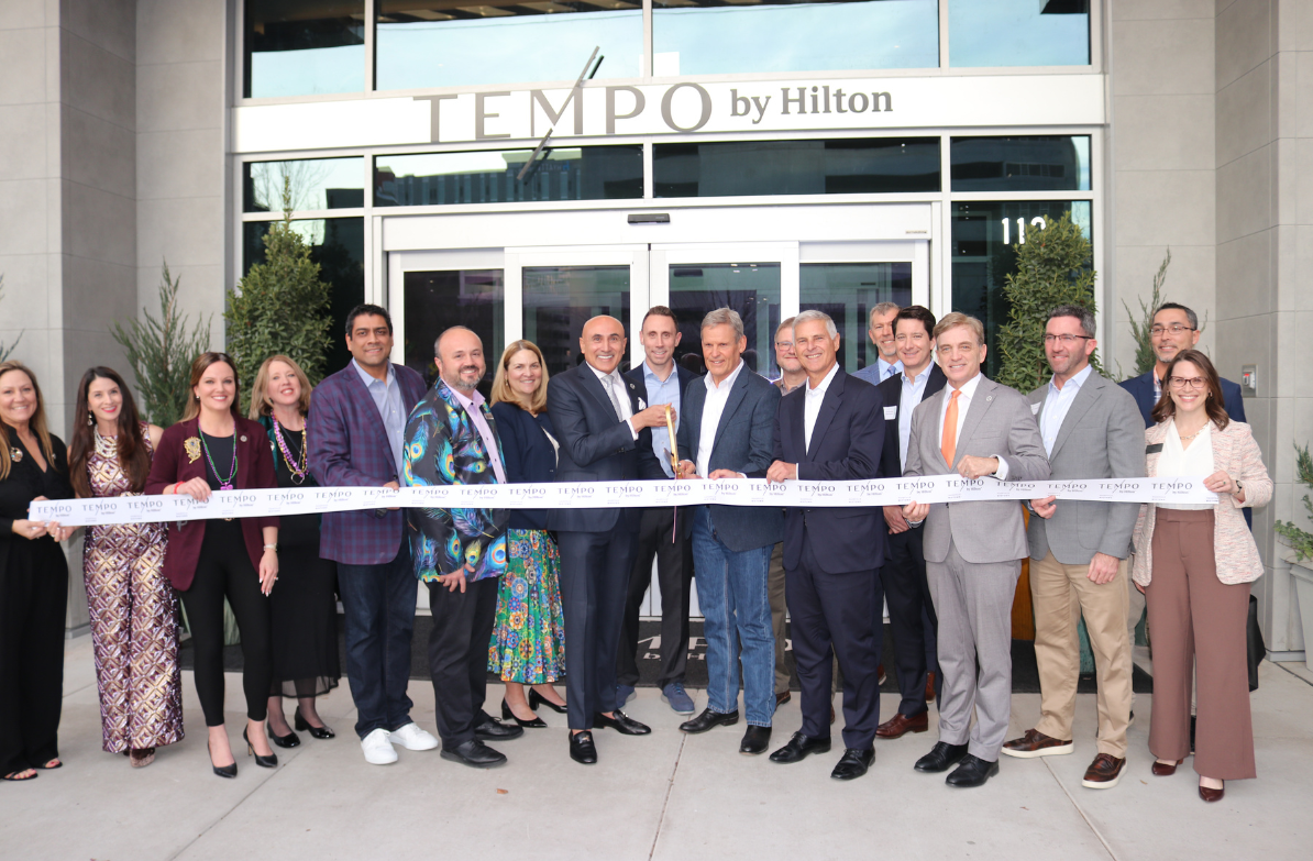 a group of people standing in front of a ribbon