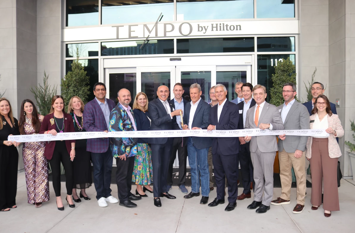 a group of people standing in front of a ribbon