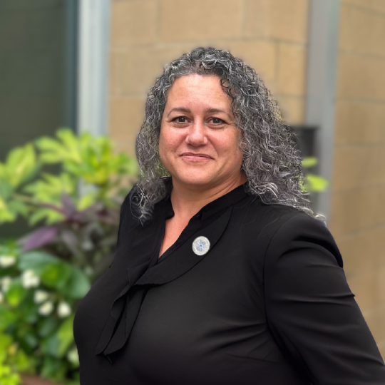a woman with long curly hair wearing a black shirt
