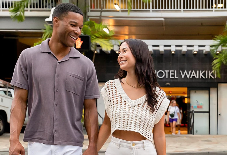 A man and woman walk in front of a hotel entrance