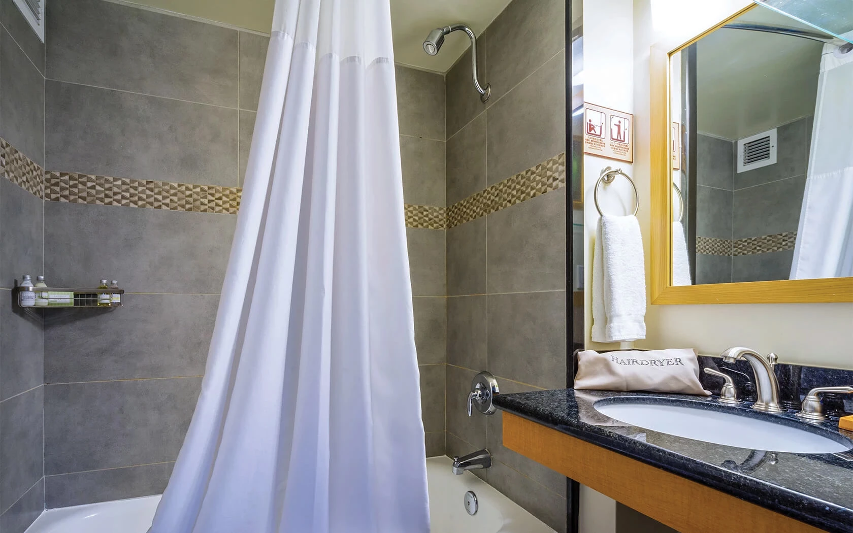 A bathroom with a shower, sink, and mirror