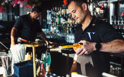 a man pouring a drink into a bottle