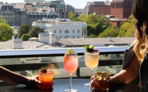 a woman holding drinks on a table