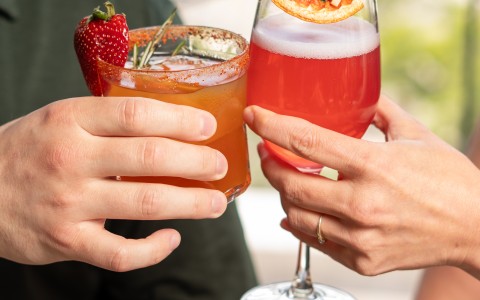 a couple of hands holding drinks
