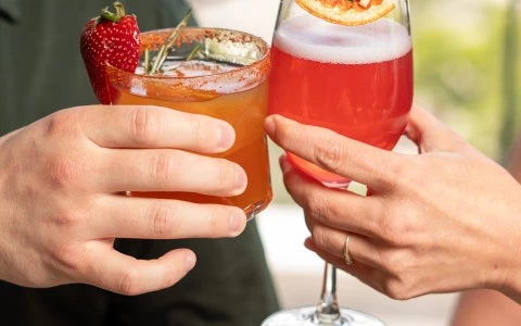 a couple of hands holding drinks