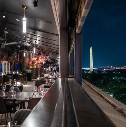 a restaurant with a tall monument in the background
