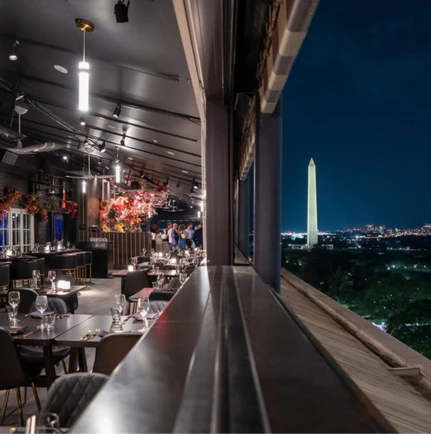 a restaurant with a tall monument in the background