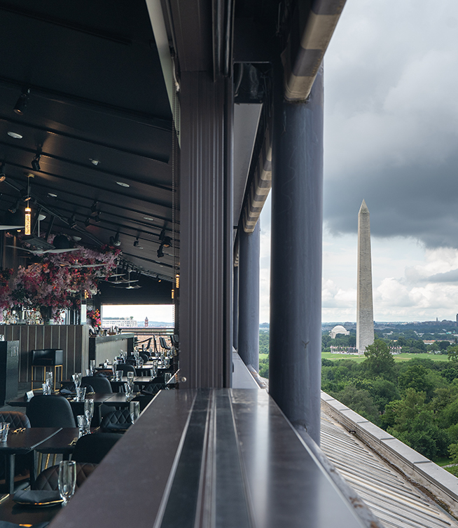 a restaurant with a tall monument in the background