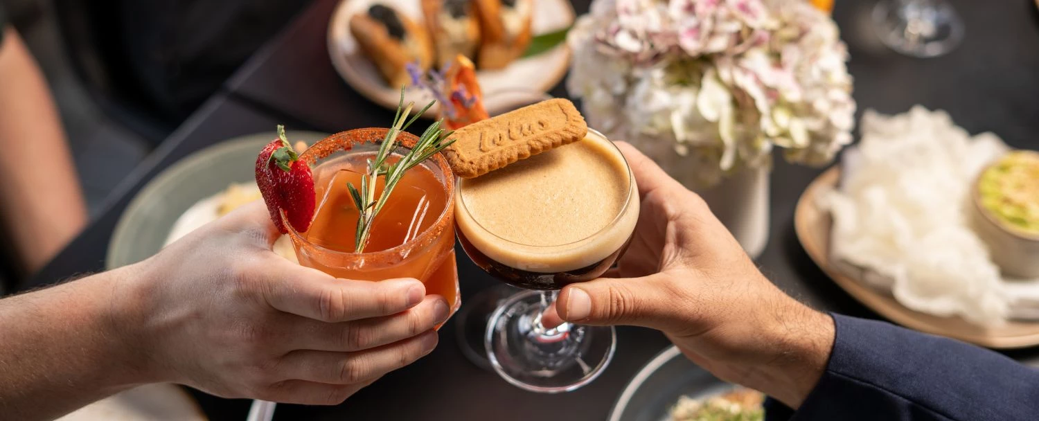 a person holding a drink and a cookie