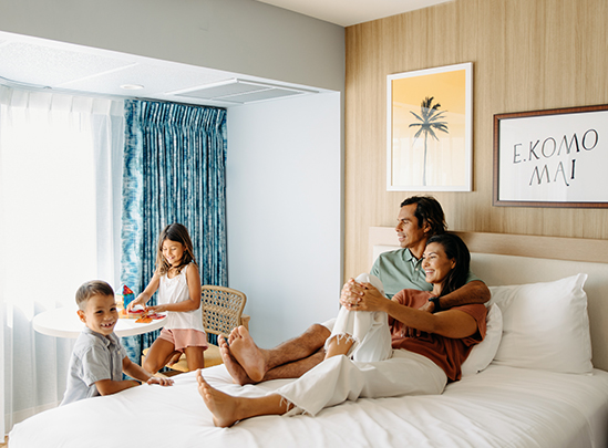 a family lying on a bed