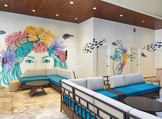 a room with a couch and a painting on the wall