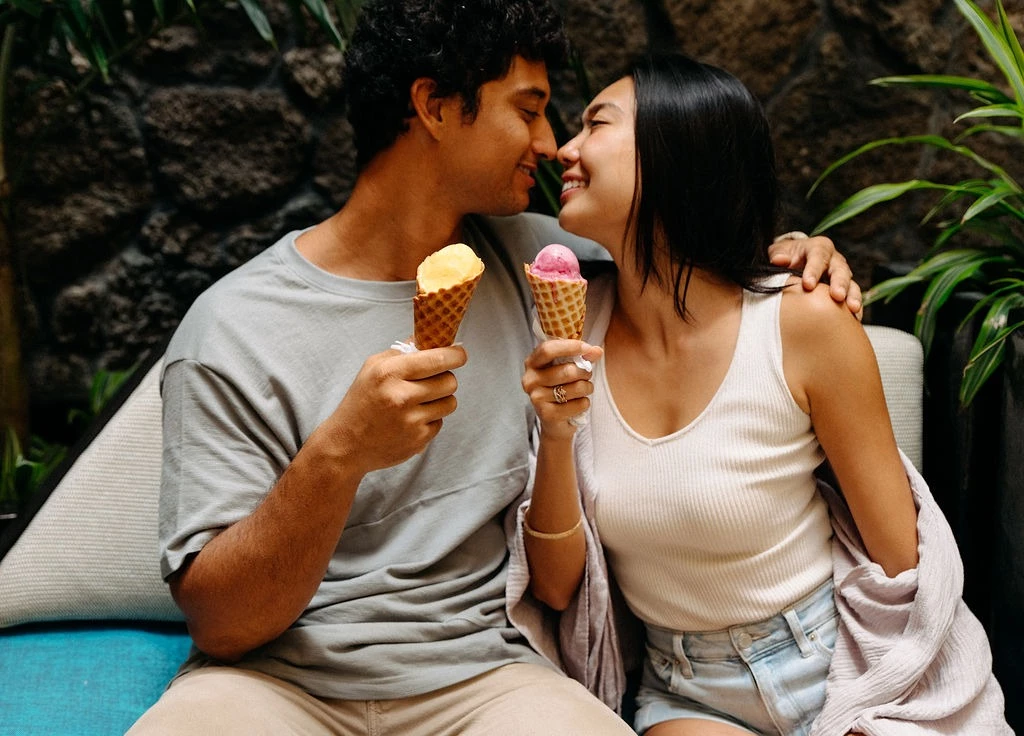 a man and woman holding ice cream cones